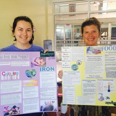 Projects Abroad interns create educational posters at their Nutrition placement in Samoa. Students hold up educational posters during their Nutrition internship in Samoa.